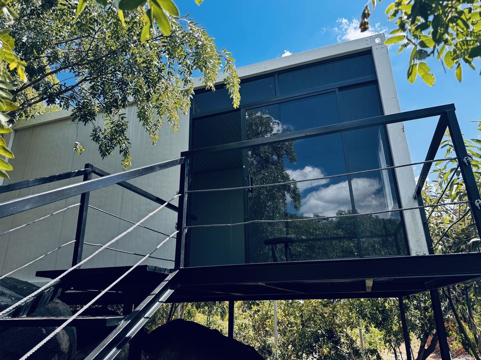 Double-storey glass container home with deck