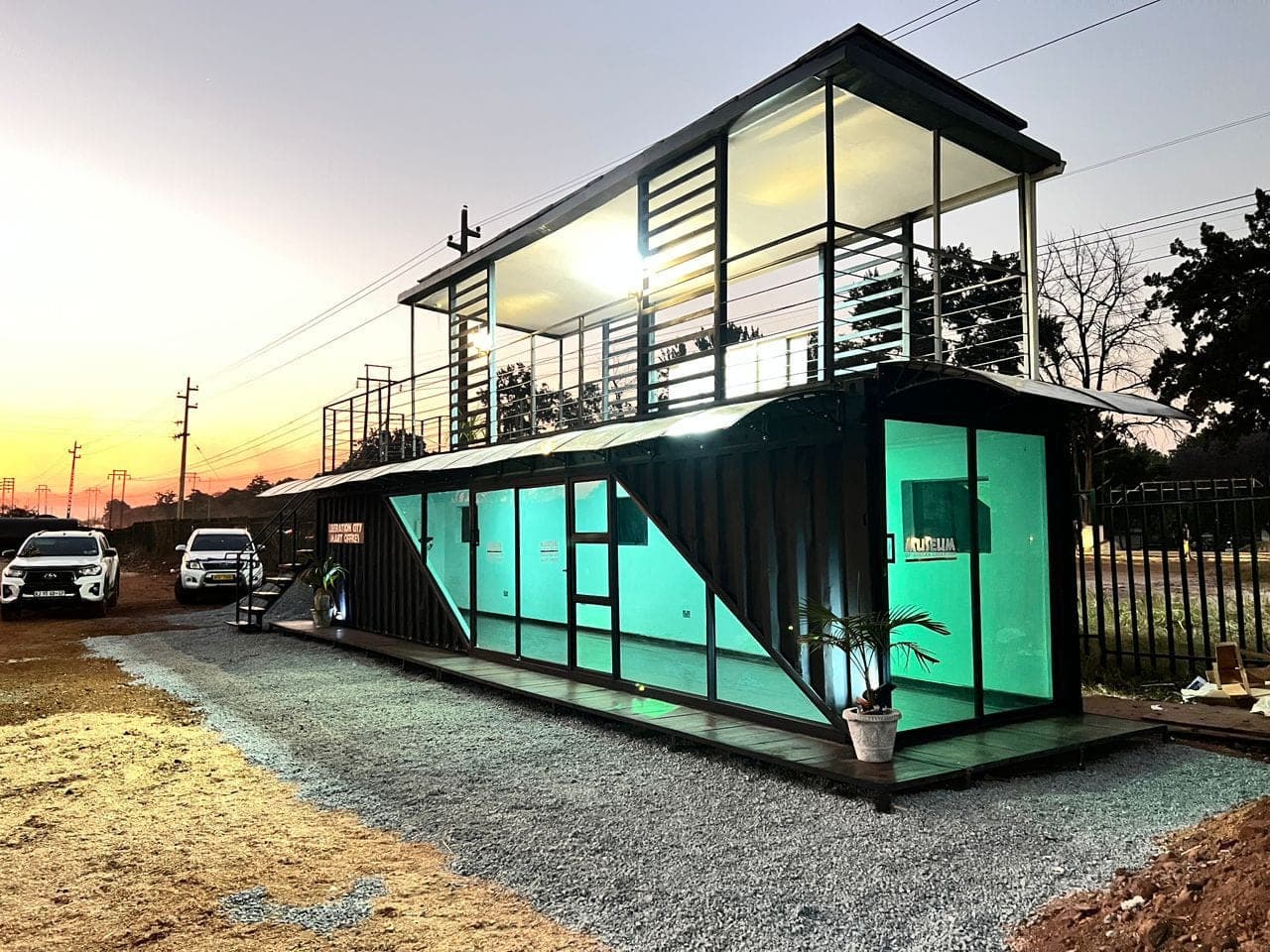 Double-storey glass container smart office lit at dusk