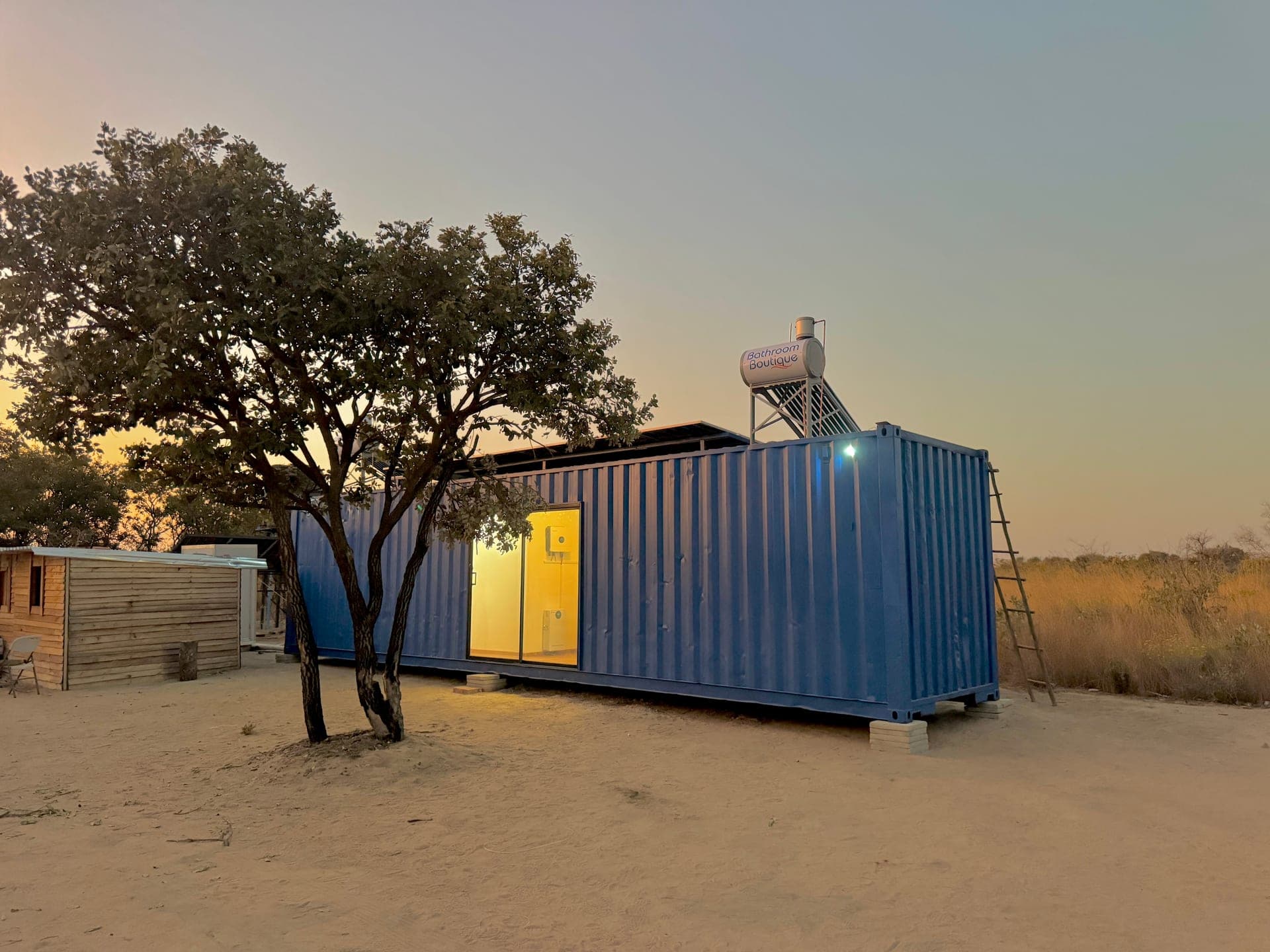 Container home lit at dusk on site